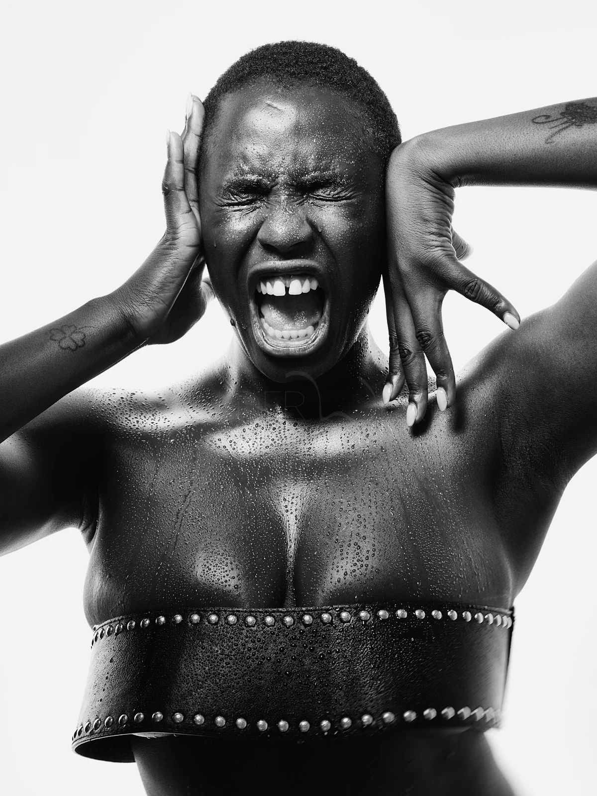 A woman laughing with both hands held beside her head.