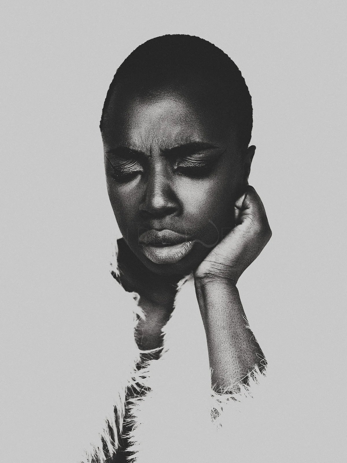 A woman resting her face in one hand, looking directly towards the camera.