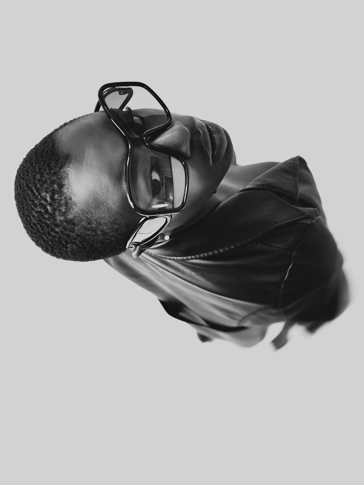 An overhead portrait of a man wearing glasses and looking up.