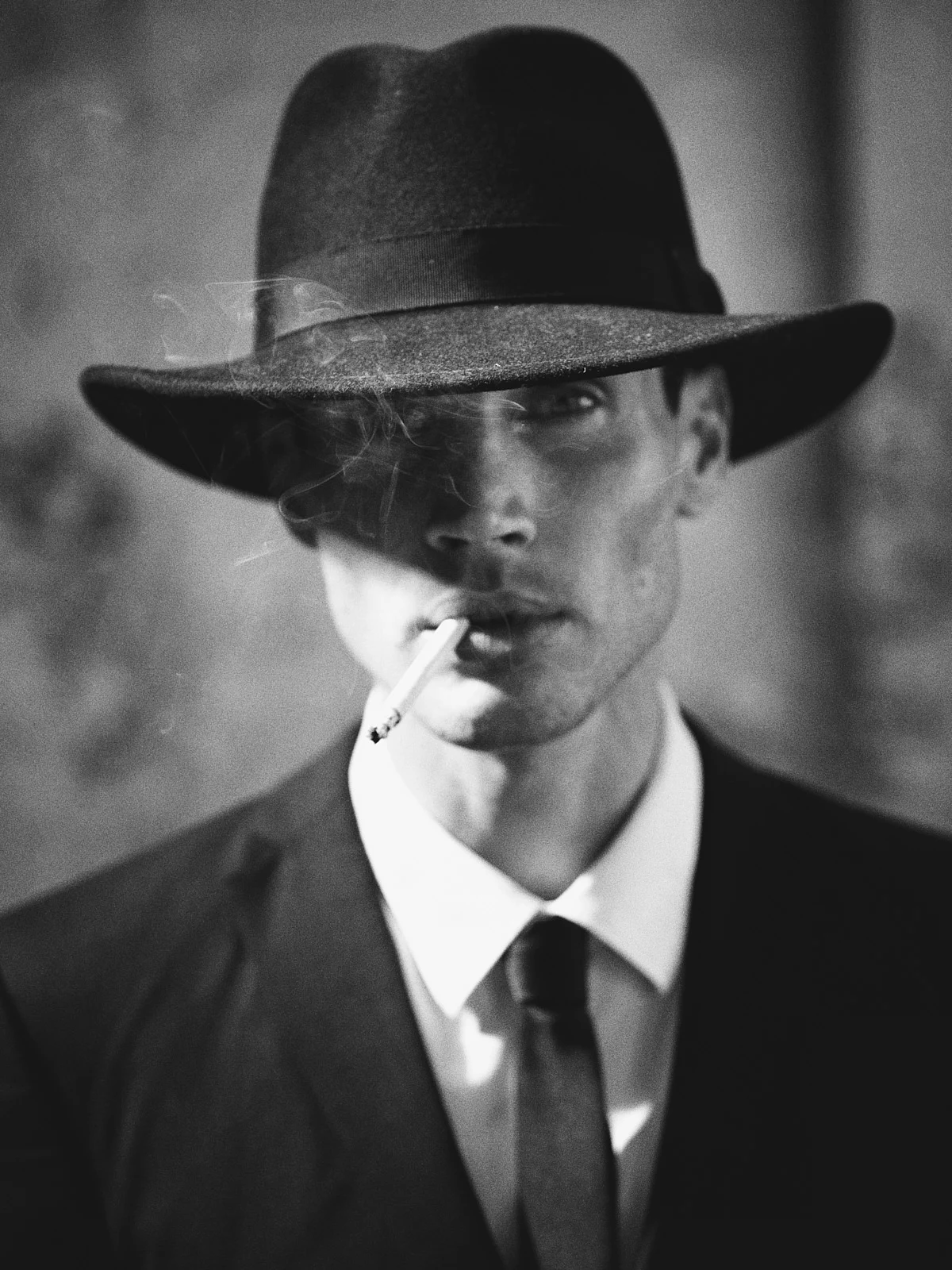 A close portrait of a man in a broad-brimmed hat and tie.