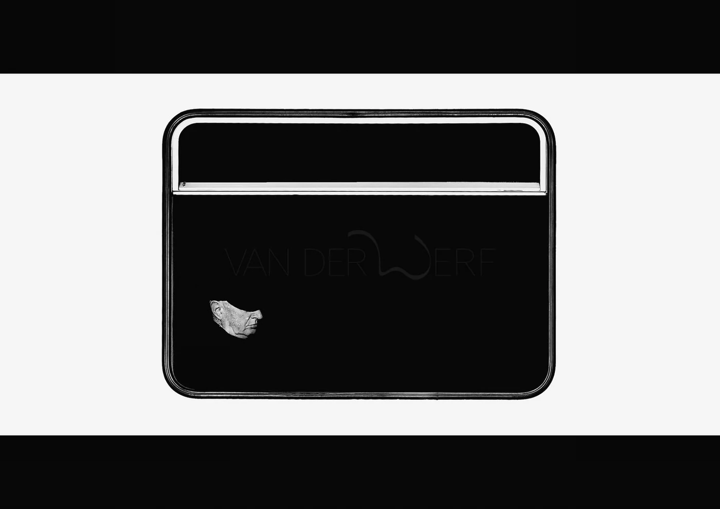 Black and white image of a window or sign with a person's face in the lower left corner, partially visible, and the text 'VAN DER WERF' in the center.