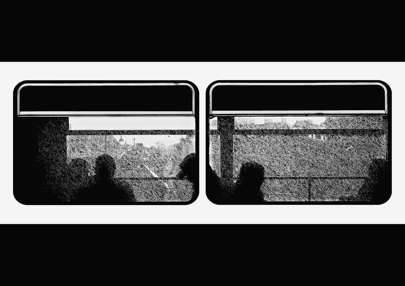Black and white image of a double-decker bus with a window reflecting trees and a person.